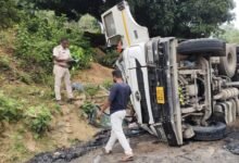 बेहड़ा मोड़ पर बालू लदा 18 चक्का ट्रेलर पलटा, दो चालक फंसे