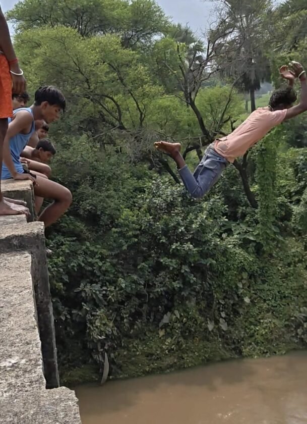 गुमानी नदी उफान पर, पुल से छलांग लगाकर जान जोखिम में डाल रहे बच्चे,हादसे की आशंका बढ़ी